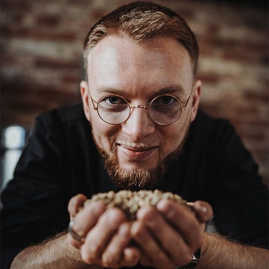 Barista Simon hält Kaffeebohnen